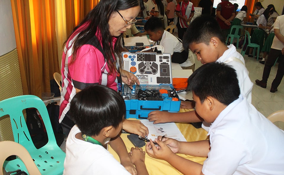 Training instructors from Science City of Muñoz guide students on different robot components.