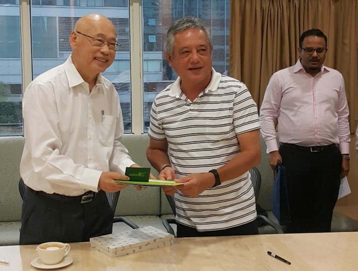 Dr. Saguiguit presents SEARCA briefing materials and a replica of the Growth Monument, SEARCA&rsquo;s institutional symbol, to Mr. Lim. Looking on is Mr. Vignesh Naidu, Research and Project Manager.